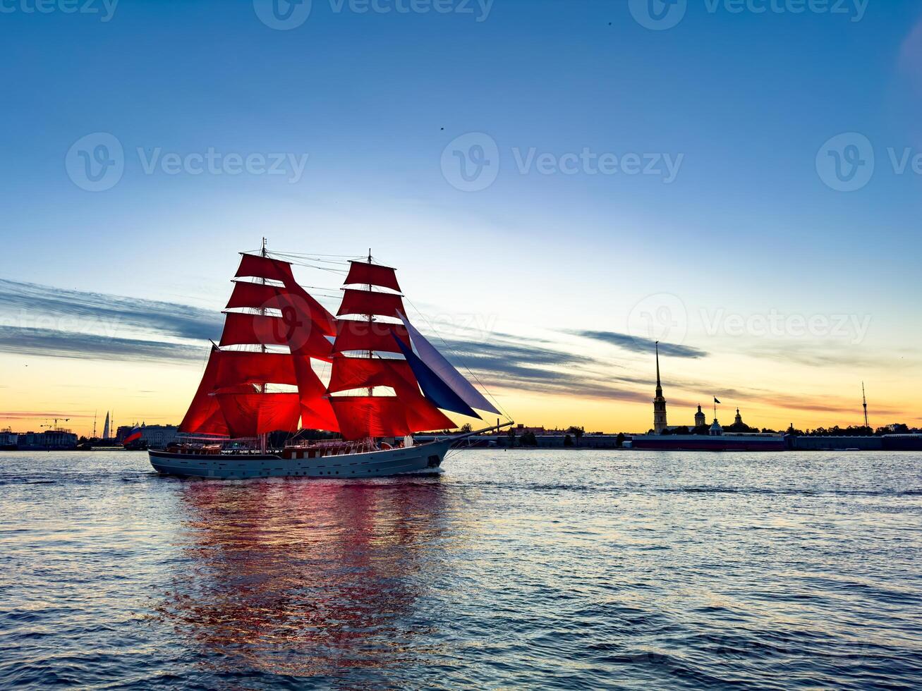 A breathtaking view of a majestic ship with vibrant red sails gliding along the Neva River during sunset in St. Petersburg, Russia. photo