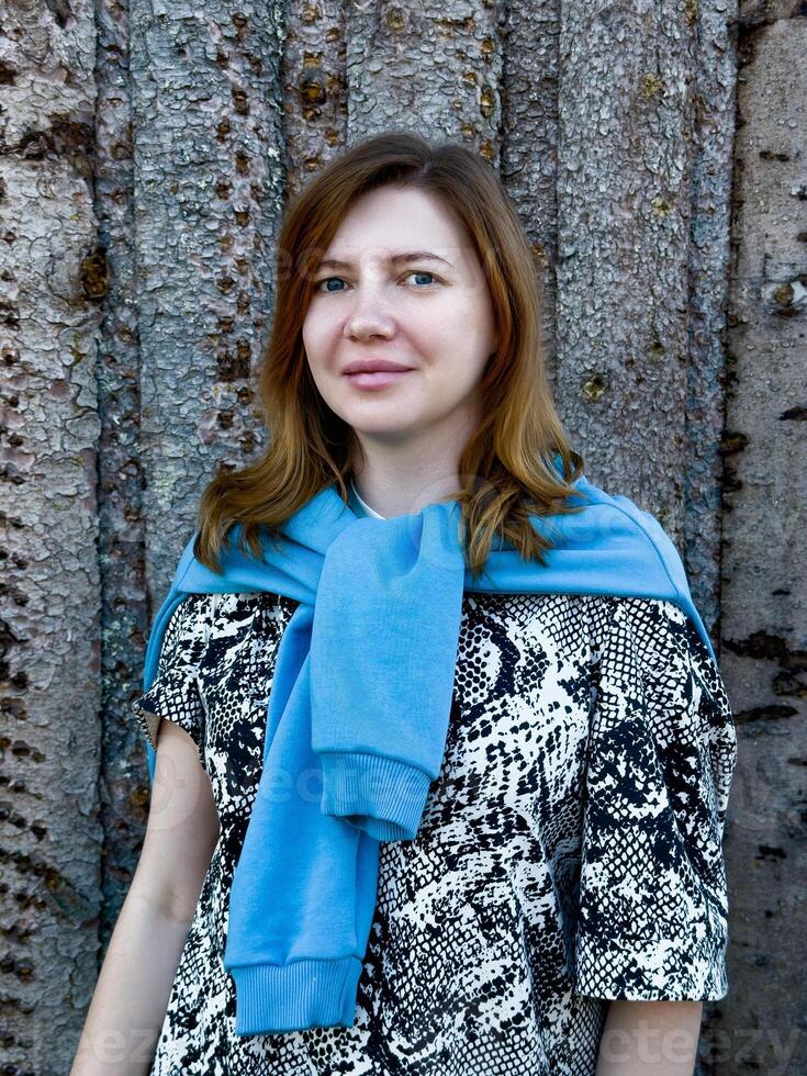 A close-up portrait of a young woman enjoying the natural beauty of a forest setting. Ideal for themes of mindfulness, serenity, and connection with nature photo
