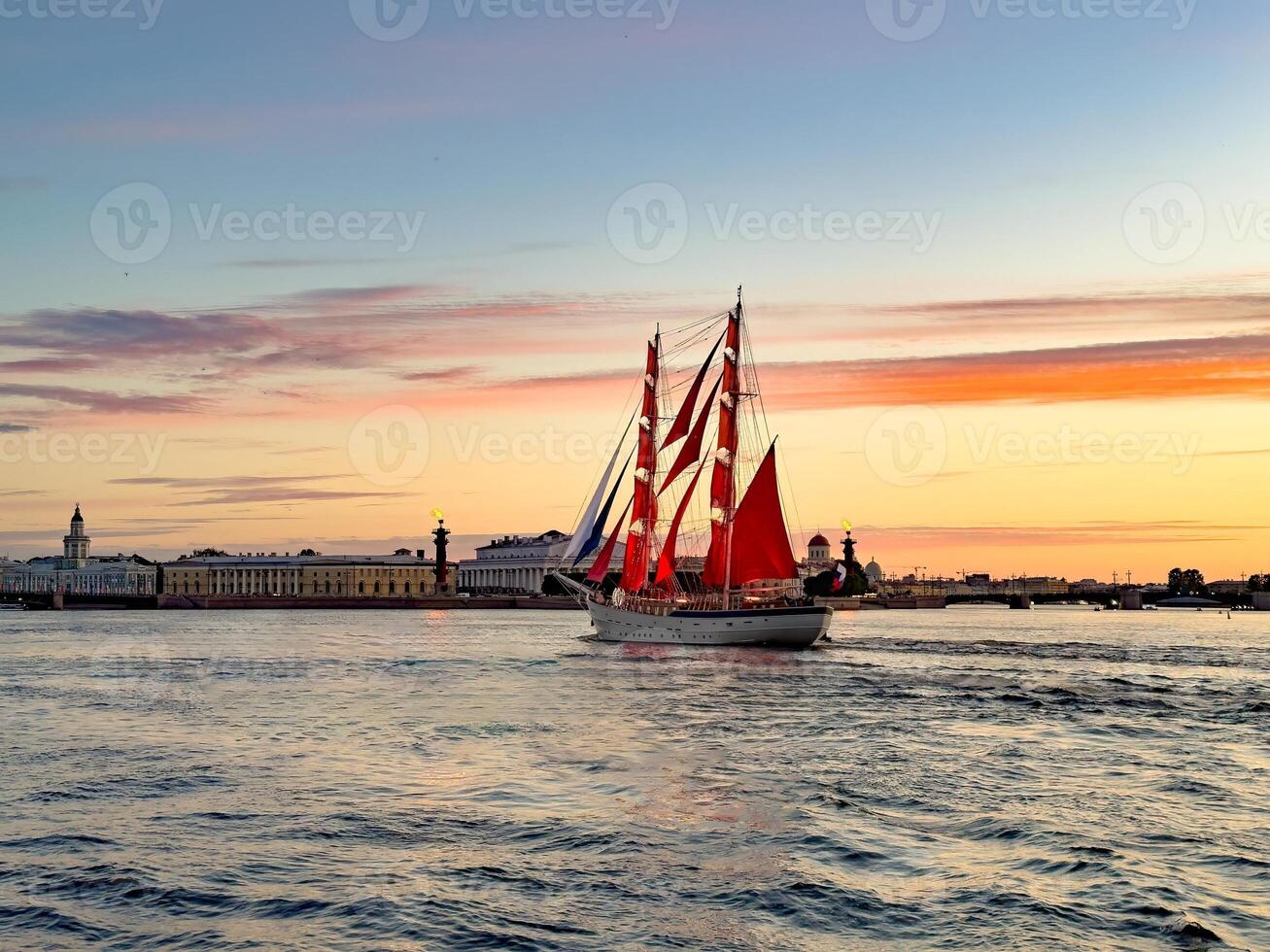 A breathtaking view of a majestic ship with vibrant red sails gliding along the Neva River during sunset in St. Petersburg, Russia. photo