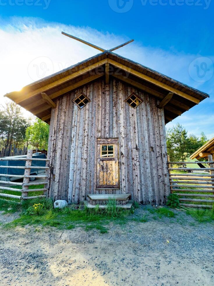 A charming rustic cabin nestled in the heart of a forest, showcasing traditional wooden architecture. Ideal for themes of countryside living, nature retreats, and rustic charm photo