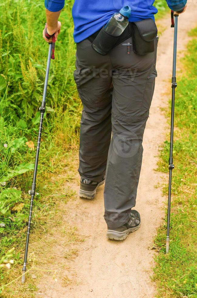 A man with Scandinavian sticks in the forest. Active lifestyle. Walking. High quality photo