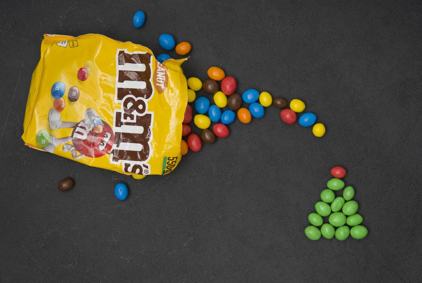 Candy Christmas Tree, M and M's in packaging on a black background, Glazed nuts pour out of the package, October 14, 2021, As, Belgium photo