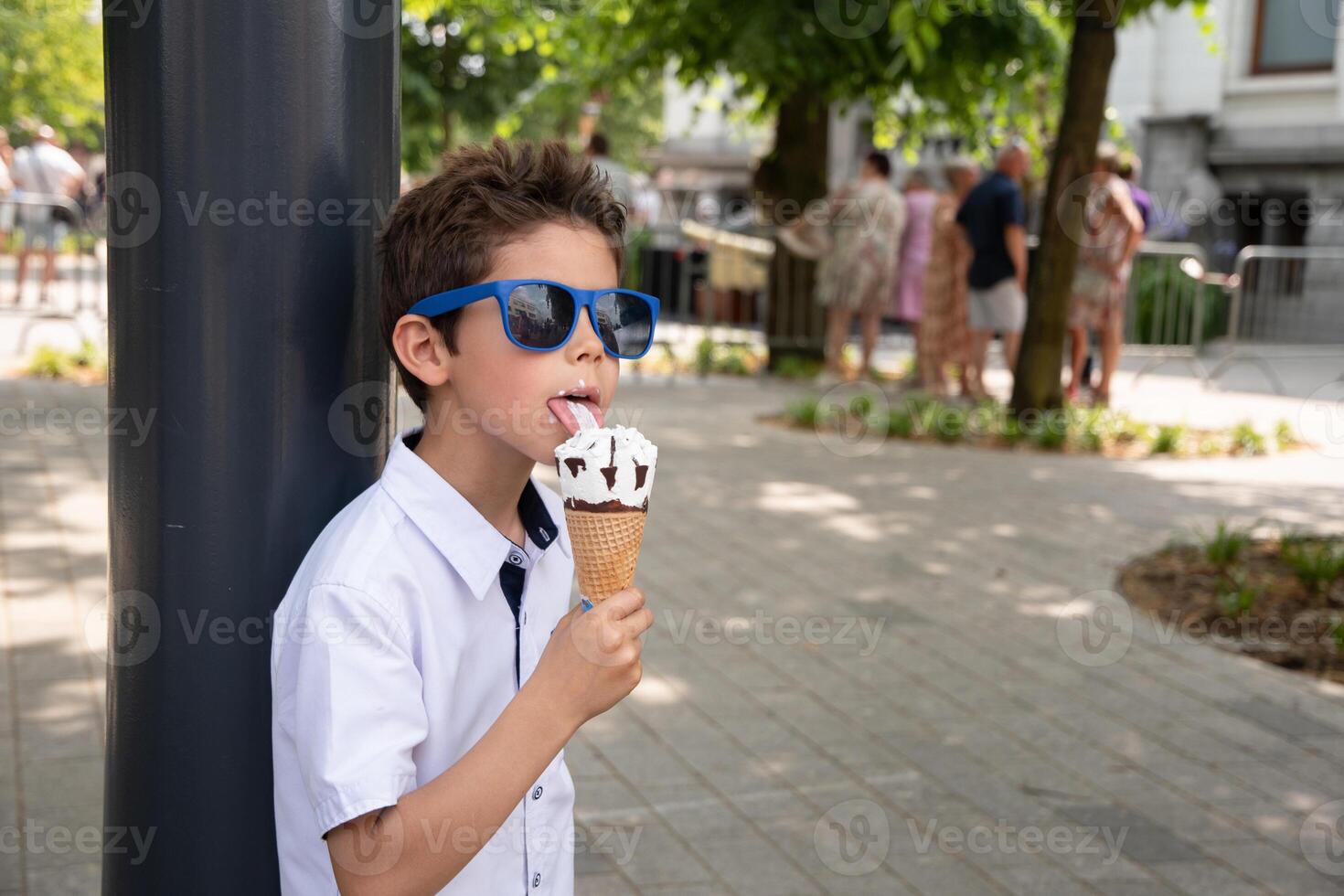 Cute child boy with a dirty face eats ice cream, the child enjoys dessert, walk in the park, High quality photo
