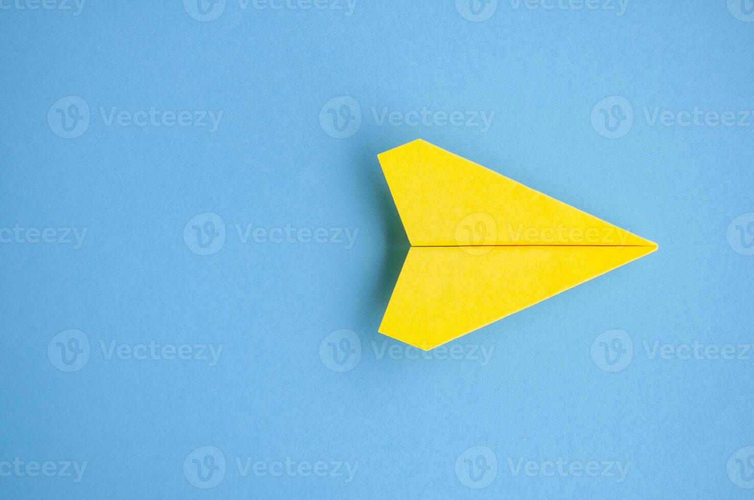Top view of yellow paper airplane with customizable space for text or ideas photo