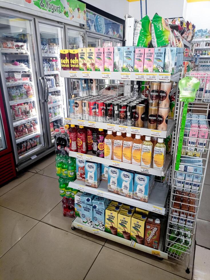 Aisle with various kinds of goods on the shelves inside Alfamart ,one of Indonesia local franchice Mini market business unit. selective Focus image. Bandung-Indonesia,February 27 2024 photo