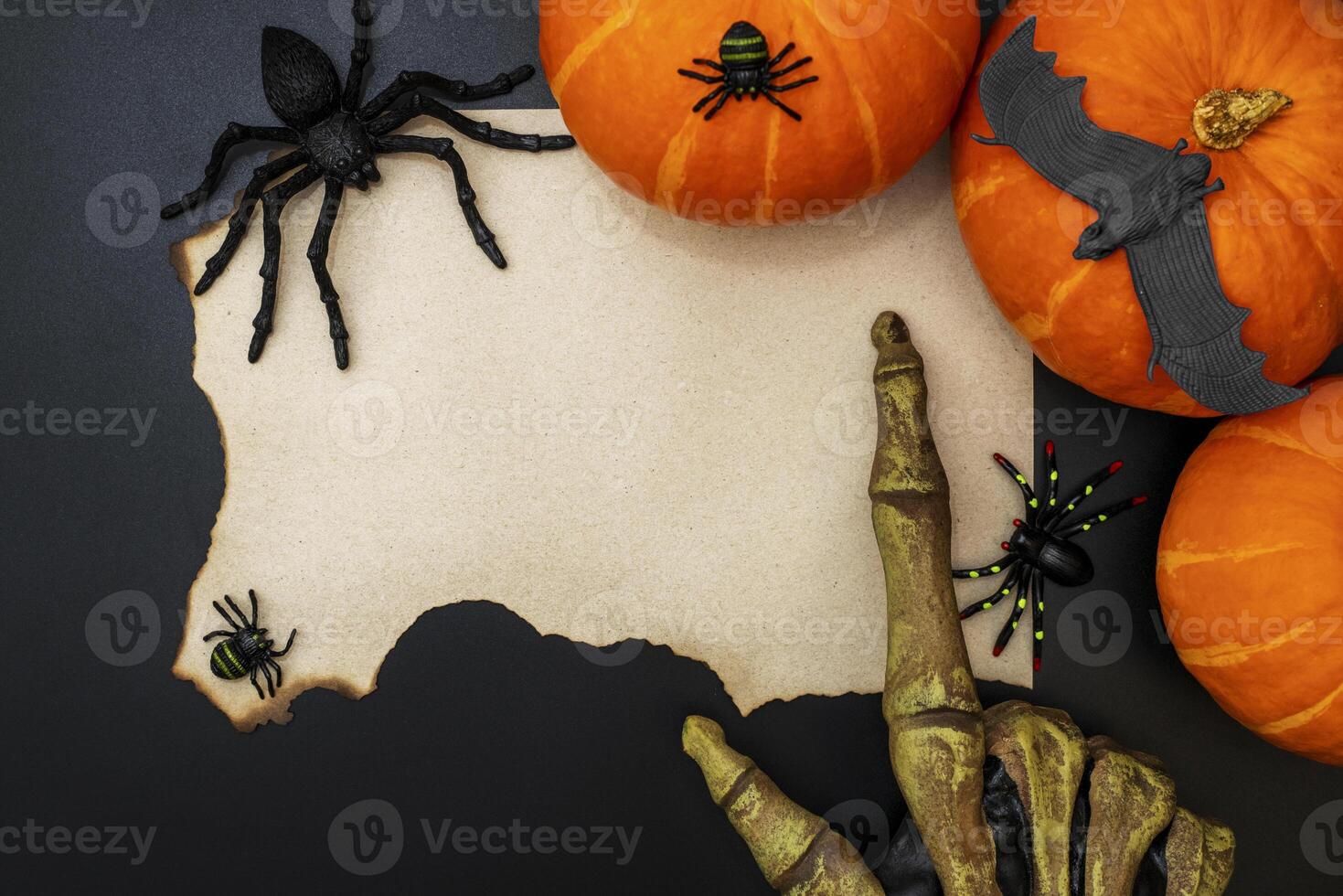 Sheet of paper with spiders, bats, pumpkin and monsters hand on black background photo