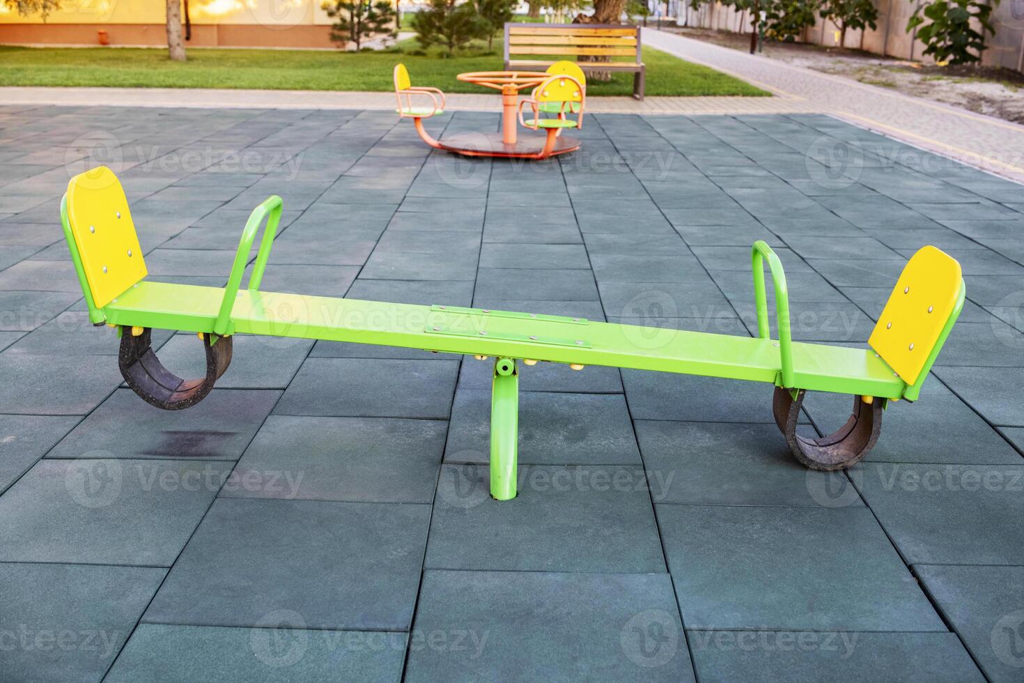 Empty seesaw on playground with soft rubber flooring in public park photo