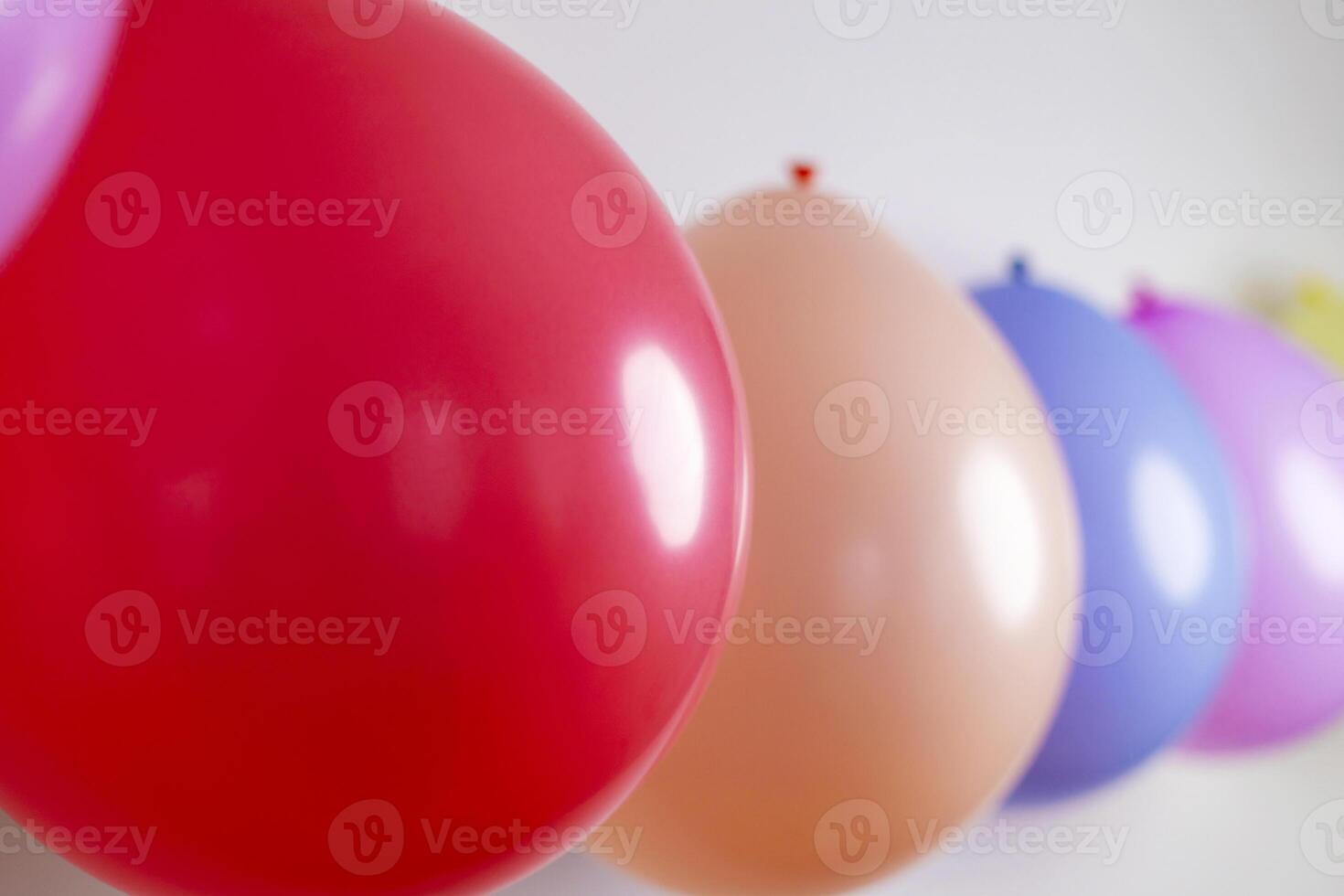 Multicolored balloons in a row with selective focus on a red balloon photo