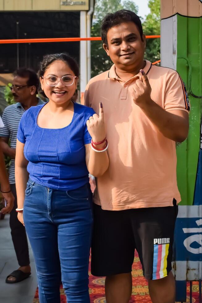 New Delhi, India - May 25 2024 - Unidentified people showing their ink-marked fingers after casting votes in front of polling booth of east Delhi area for general Lok Sabha Elections 2024 photo