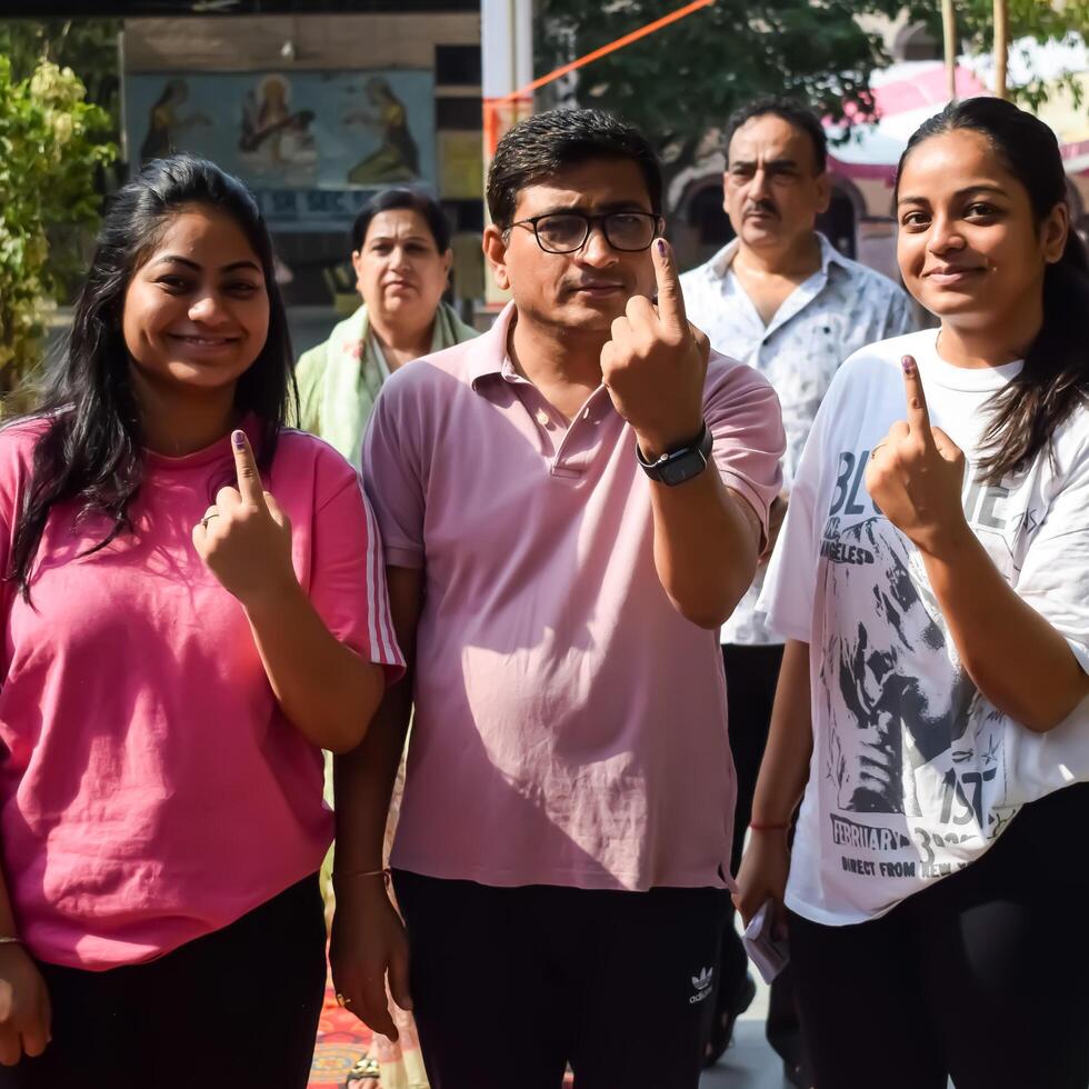 New Delhi, India - May 25 2024 - Unidentified people showing their ink-marked fingers after casting votes in front of polling booth of east Delhi area for general Lok Sabha Elections 2024 photo