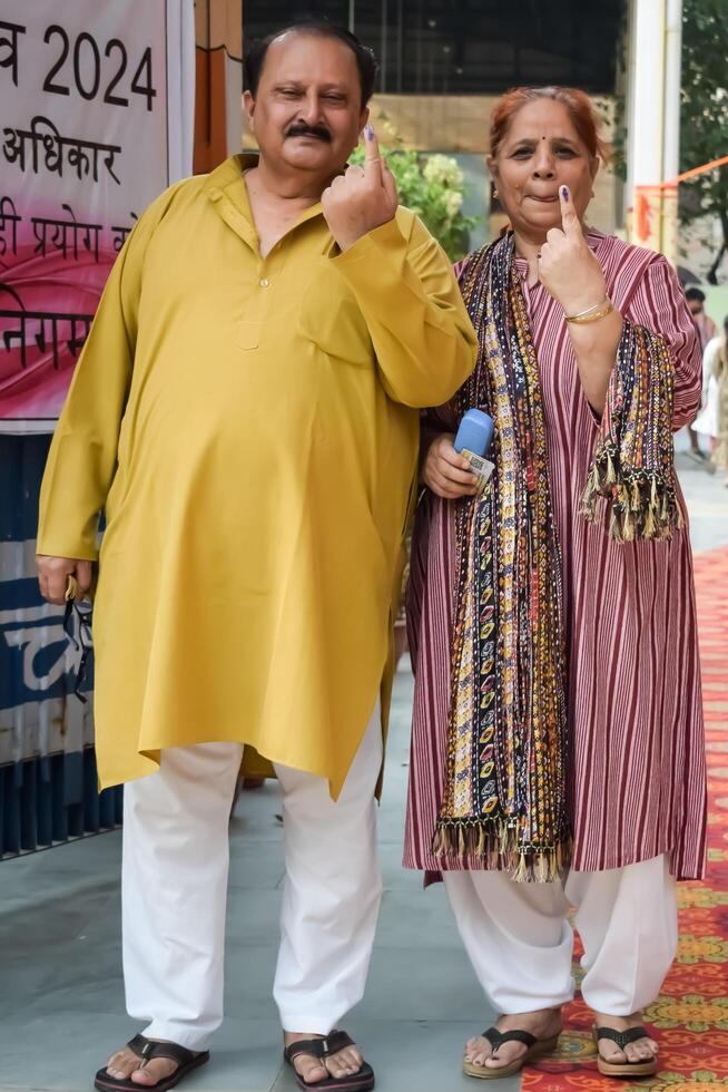 New Delhi, India - May 25 2024 - Unidentified people showing their ink-marked fingers after casting votes in front of polling booth of east Delhi area for general Lok Sabha Elections 2024 photo