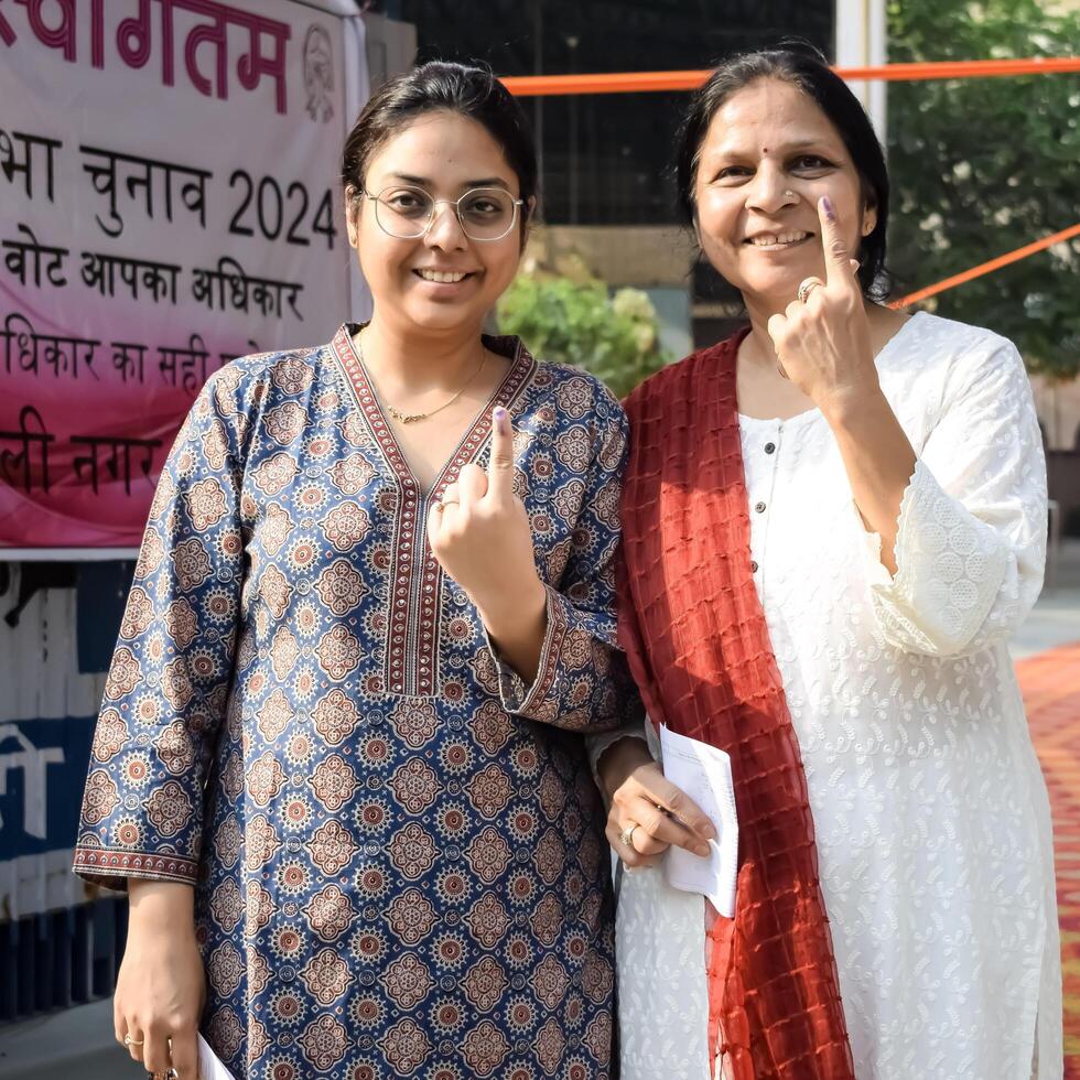 New Delhi, India - May 25 2024 - Unidentified people showing their ink-marked fingers after casting votes in front of polling booth of east Delhi area for general Lok Sabha Elections 2024 photo