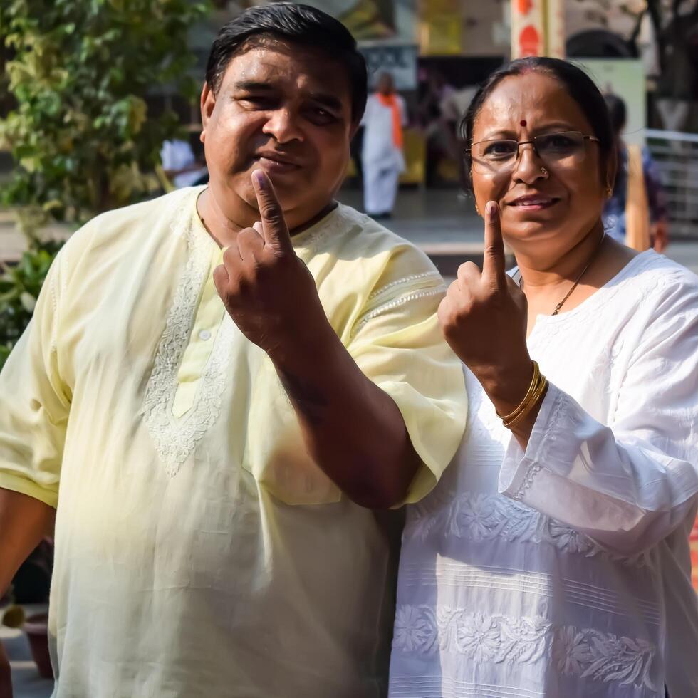 New Delhi, India - May 25 2024 - Unidentified people showing their ink-marked fingers after casting votes in front of polling booth of east Delhi area for general Lok Sabha Elections 2024 photo
