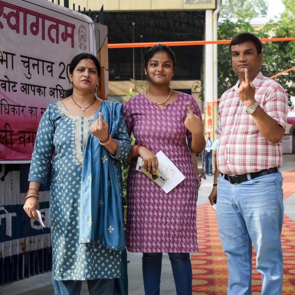 New Delhi, India - May 25 2024 - Unidentified people showing their ink-marked fingers after casting votes in front of polling booth of east Delhi area for general Lok Sabha Elections 2024 photo