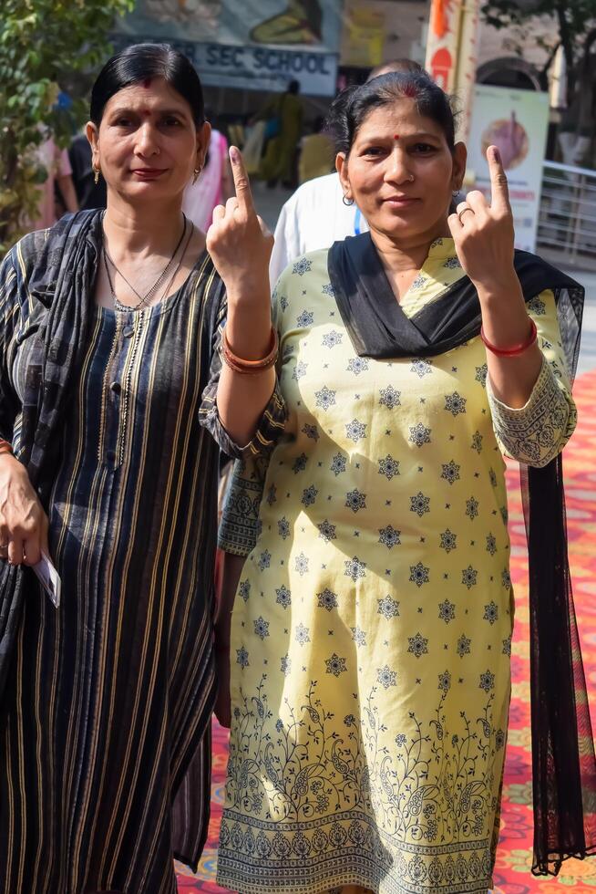 New Delhi, India - May 25 2024 - Unidentified people showing their ink-marked fingers after casting votes in front of polling booth of east Delhi area for general Lok Sabha Elections 2024 photo