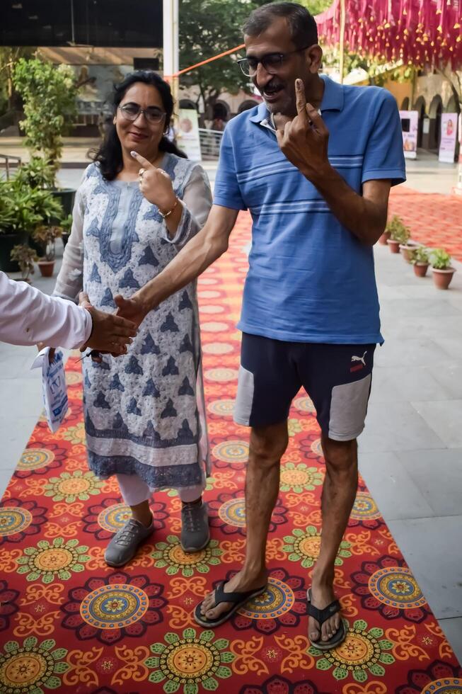 New Delhi, India - May 25 2024 - Unidentified people showing their ink-marked fingers after casting votes in front of polling booth of east Delhi area for general Lok Sabha Elections 2024 photo