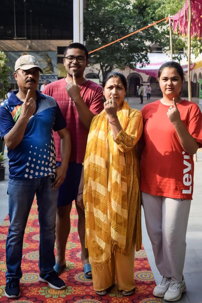 New Delhi, India - May 25 2024 - Unidentified people showing their ink-marked fingers after casting votes in front of polling booth of east Delhi area for general Lok Sabha Elections 2024 photo
