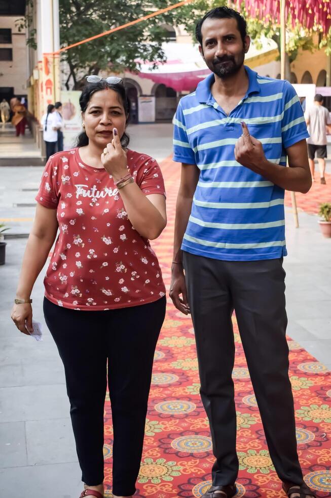 New Delhi, India - May 25 2024 - Unidentified people showing their ink-marked fingers after casting votes in front of polling booth of east Delhi area for general Lok Sabha Elections 2024 photo