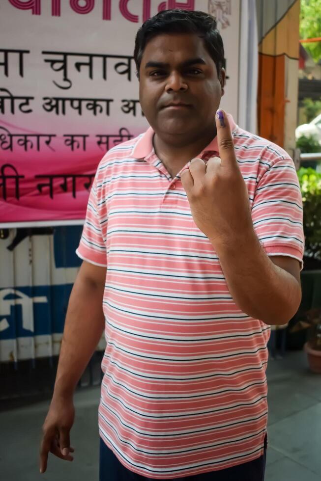 New Delhi, India - May 25 2024 - Unidentified people showing their ink-marked fingers after casting votes in front of polling booth of east Delhi area for general Lok Sabha Elections 2024 photo