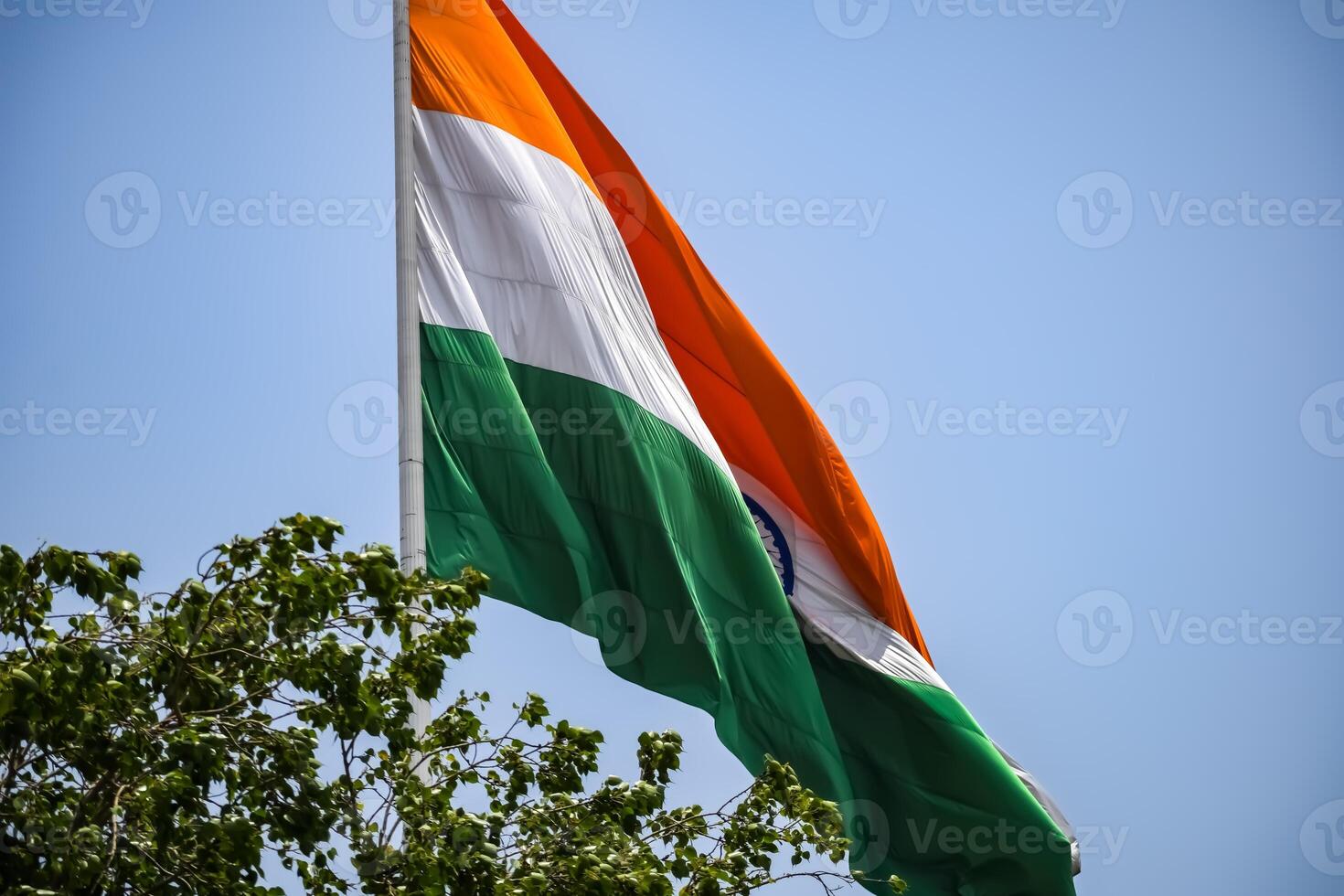 India flag flying high at Connaught Place with pride in blue sky, India flag fluttering, Indian Flag on Independence Day and Republic Day of India, tilt up shot, Waving Indian flag, Har Ghar Tiranga photo