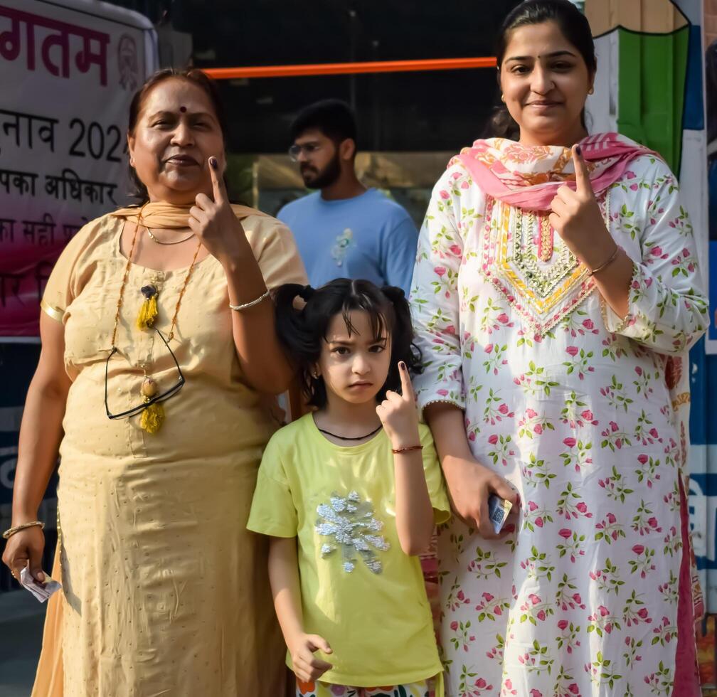 New Delhi, India - May 25 2024 - Unidentified people showing their ink-marked fingers after casting votes in front of polling booth of east Delhi area for general Lok Sabha Elections 2024 photo