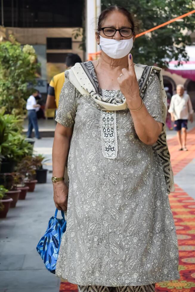 New Delhi, India - May 25 2024 - Unidentified people showing their ink-marked fingers after casting votes in front of polling booth of east Delhi area for general Lok Sabha Elections 2024 photo