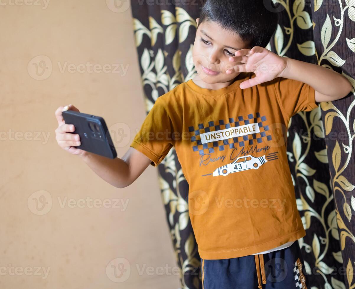 Portrait of Asian smart happy little boy using Mobile phone at home. Little boy holding mobile smart phone, online back to school concept. Online Class concept photo