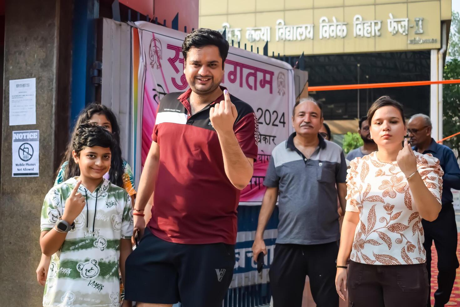 New Delhi, India - May 25 2024 - Unidentified people showing their ink-marked fingers after casting votes in front of polling booth of east Delhi area for general Lok Sabha Elections 2024 photo