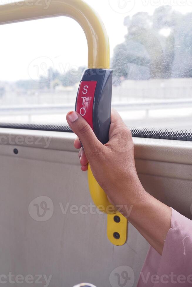 hand pressing the Bus bell switch for stop inside the public bus photo