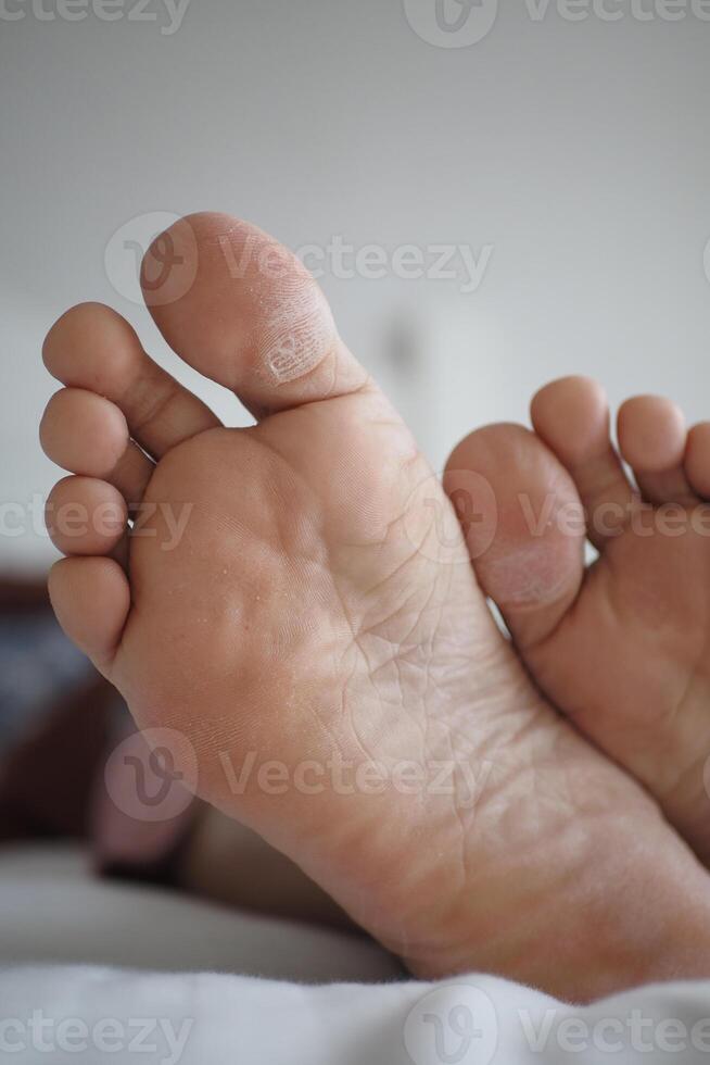 close up of young man dry feet on bed , photo