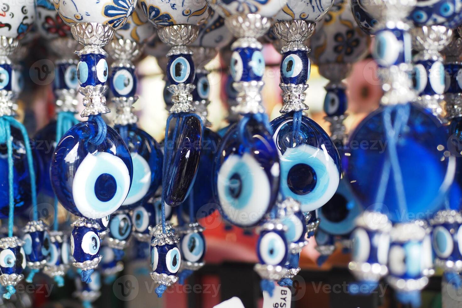 a bunch of blue evil eye keychains hanging on a shelf photo