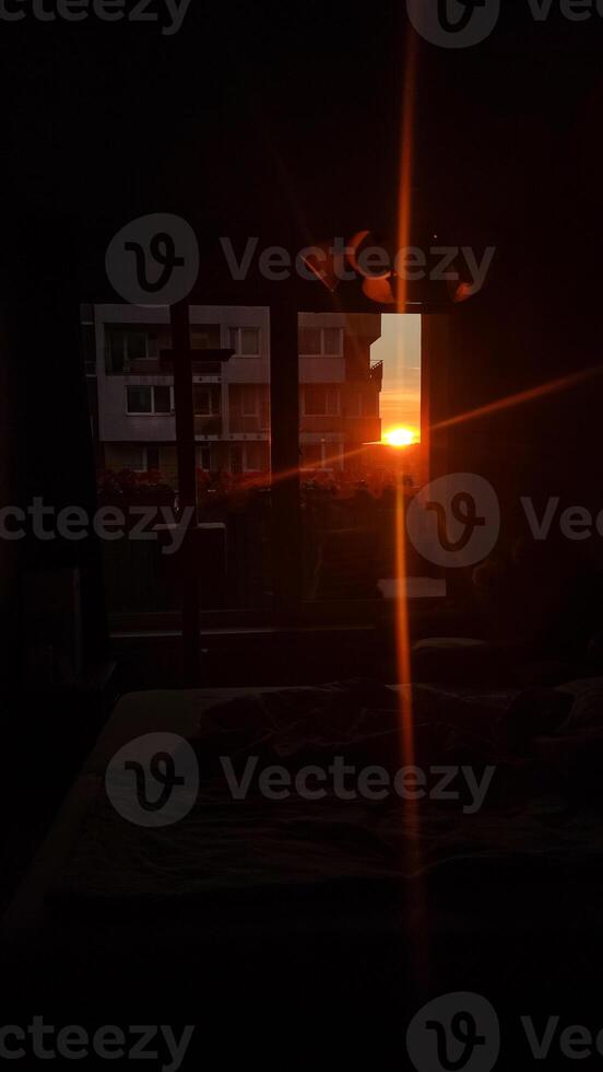 Sunlight streams through an apartment window at dusk photo