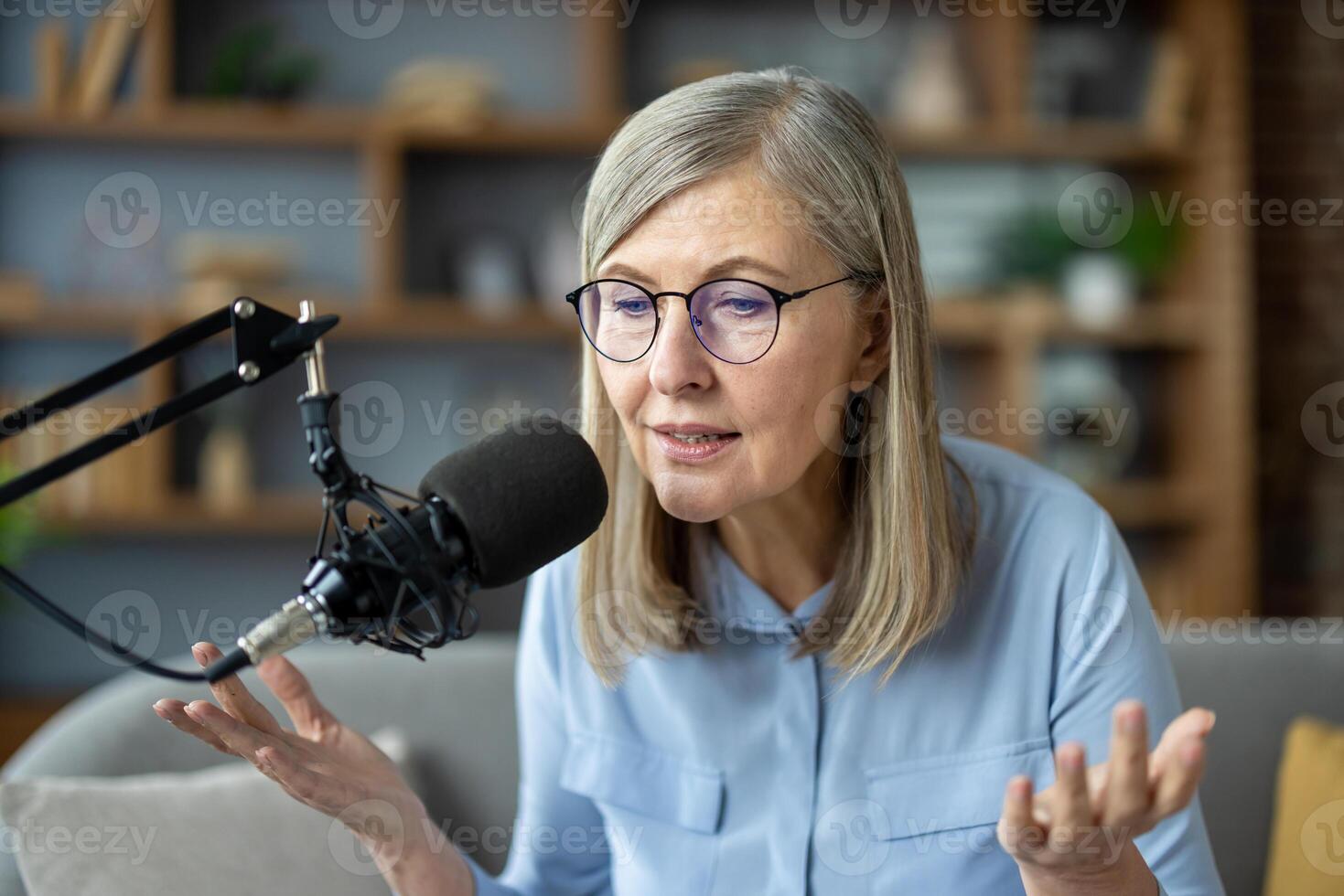 Senior woman records podcast at home, speaking into microphone. She discusses various topics, sharing knowledge and insights. photo