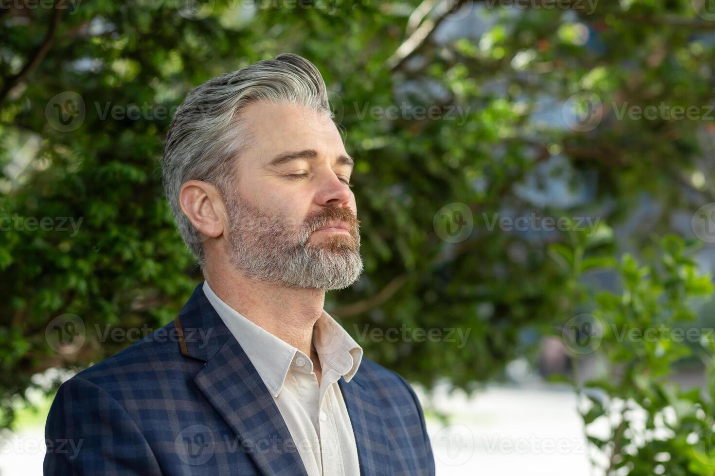 Contemplative senior executive in a business suit stands outside an office building, exuding professionalism and experience. photo