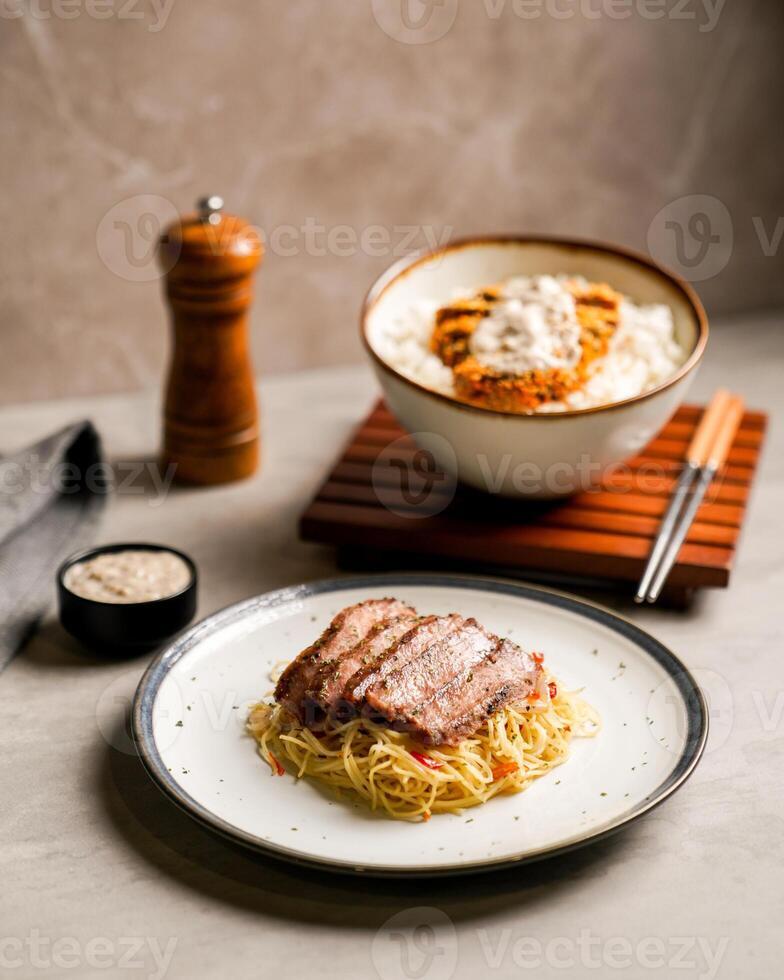 A Portion of Pasta with Beef Slices and Katsu Rice Bowl photo