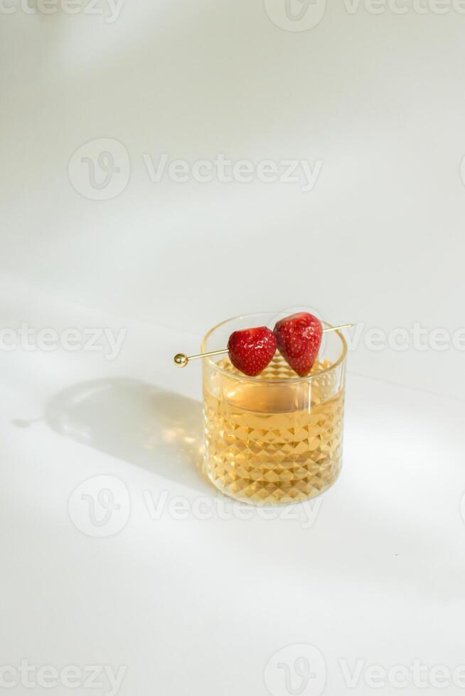 A Glass of Tea with Strawberry as a Garnish photo
