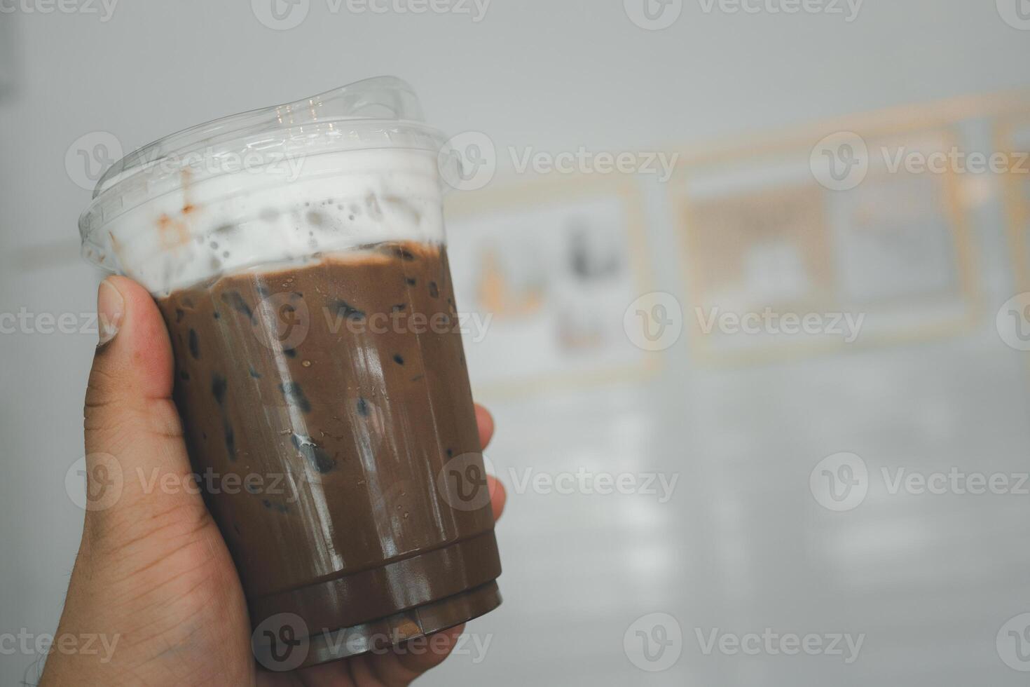 Iced coffee mocha with milk foam in man hand photo