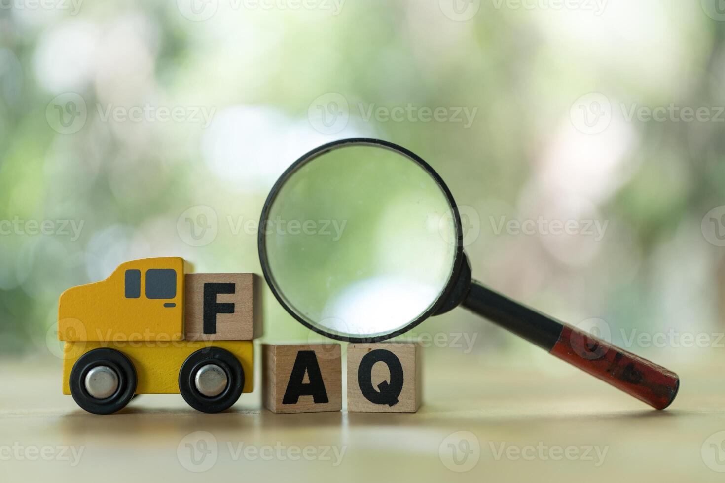 Magnifying glass on wood cubes with frequently asked questions photo