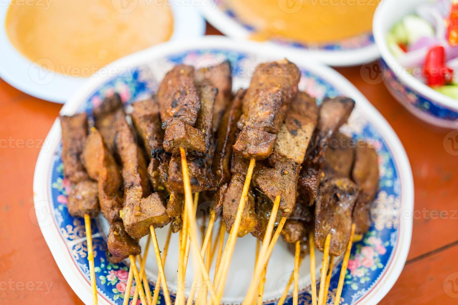 Liver satay or liver pork in bamboo skewers eaten with peanut sauce or sweet and sour sauce. photo