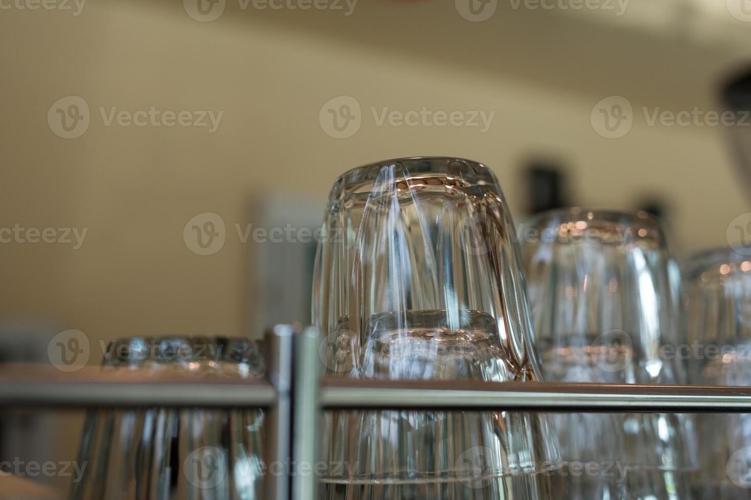 Clean glass lie upside down on a coffee machine in a cafe. Close up and selective focus. photo