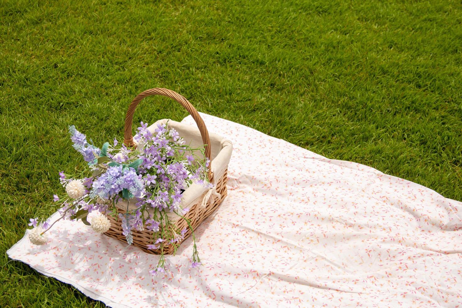 A basket of flowers lies on the beautiful grass. photo