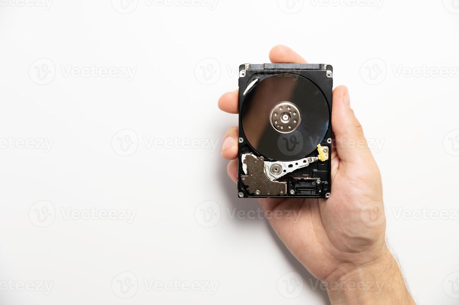 An opened hard drive in a man's hand. Data repair and recovery concept photo