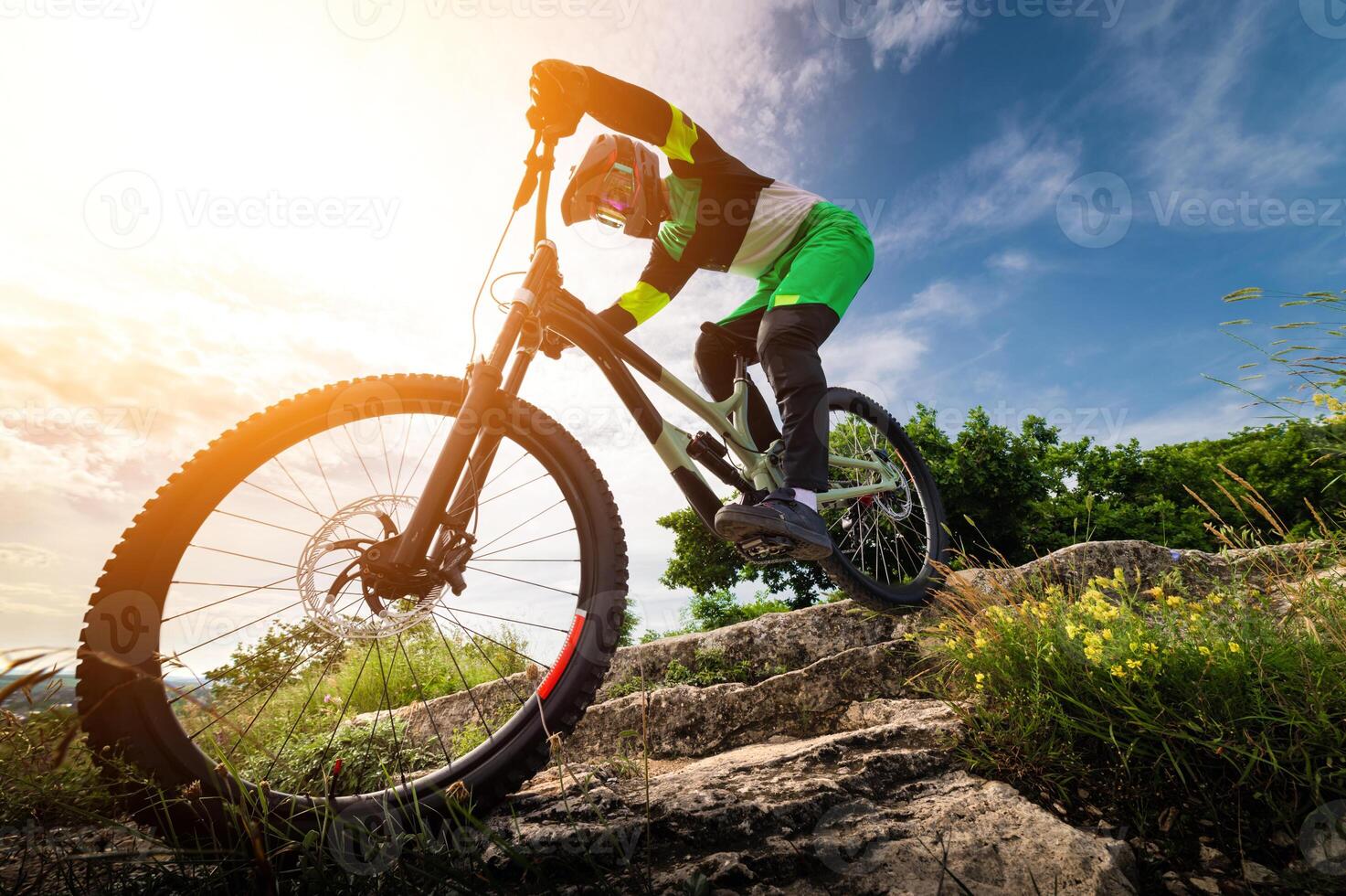 Wide angle view of a mountain biker racing down a mountain bike path in the forest. A cyclist's rapid descent over rocks photo