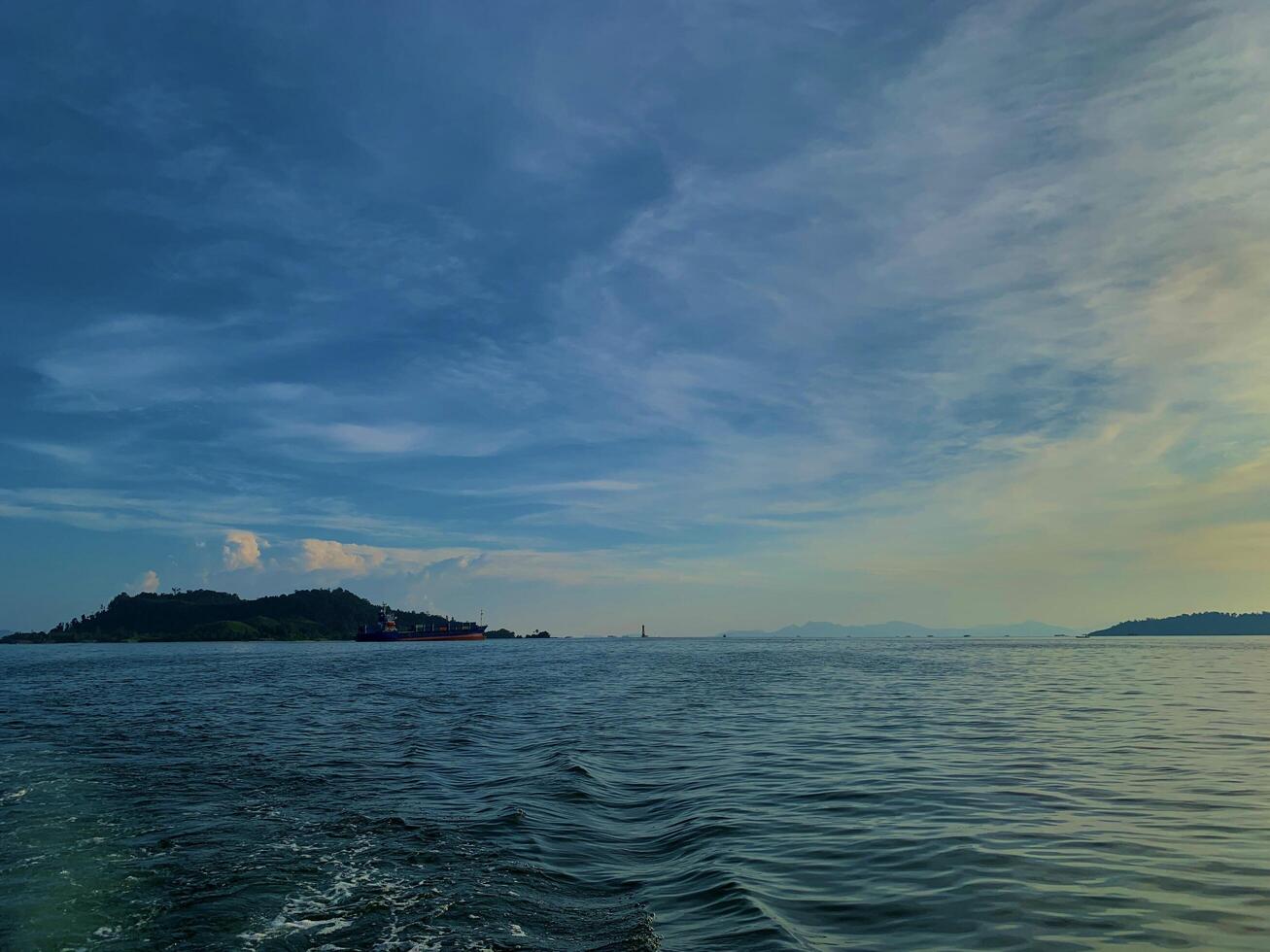 a boat in the ocean with a small island in the distance photo