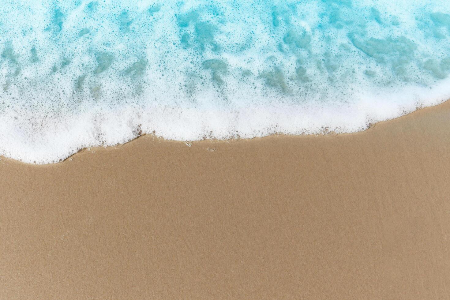 Blue ocean waves with white foam crashing on summer sand beach island top view with copy space, beautiful natural scene of tropical sand beach background. photo