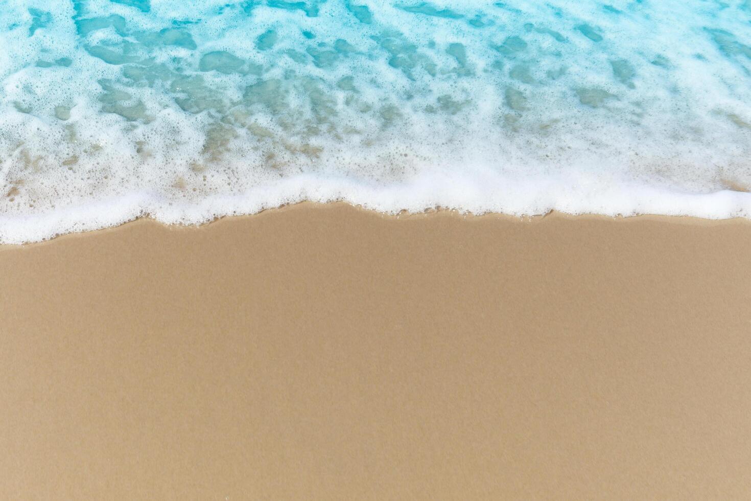 Blue ocean waves with white foam crashing on summer sand beach island top view with copy space, beautiful natural scene of tropical sand beach background. photo