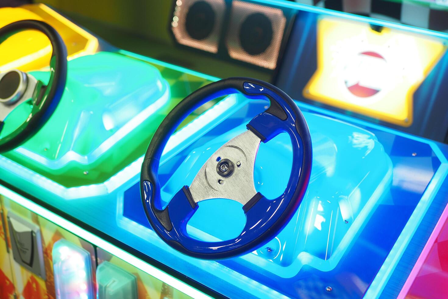 A closeup view of a illuminated steering wheel from an arcade racing game machine photo