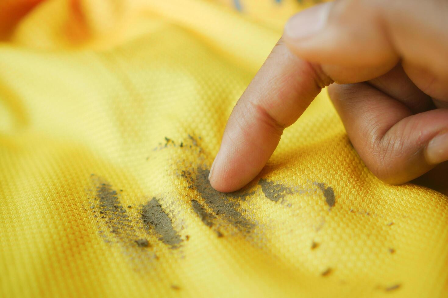 dirty mud stain on a yellow color shirt photo