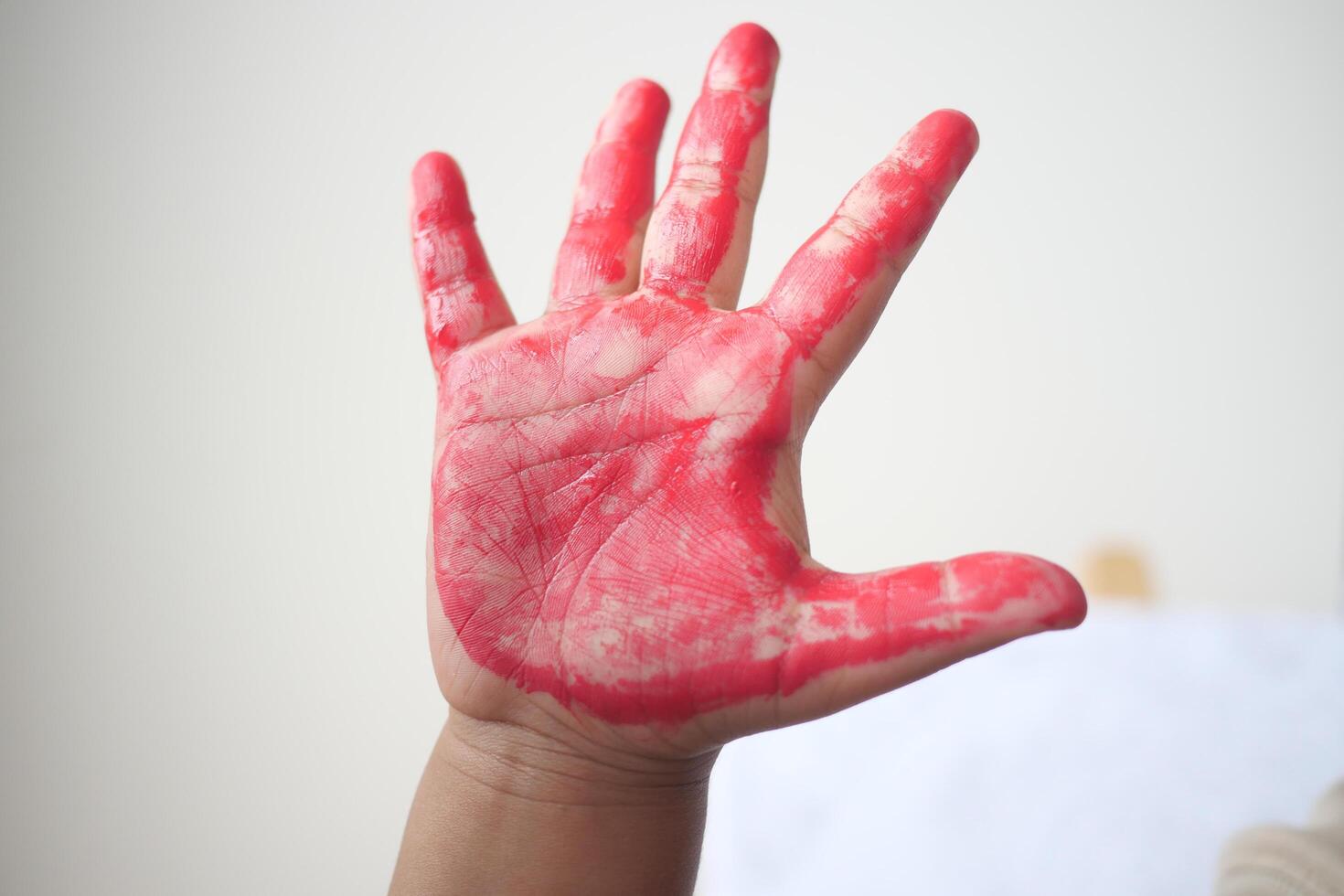During a creative art session, a childs hand was expertly covered in vibrant red paint photo