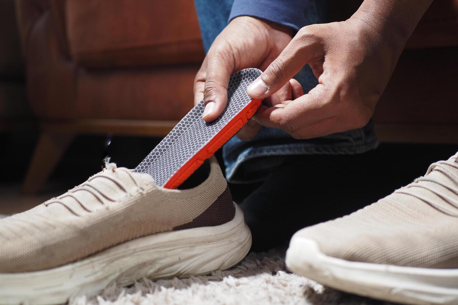 men hand putting Orthopedic insoles in shoes photo